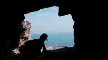 Dağın içindeki tepelere bakan kızın silueti.