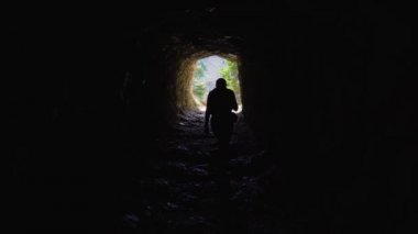 Kız dağlarda bir mağarada yürüyor.