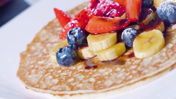 Pancakes with bananas and strawberries on top — Stock Video