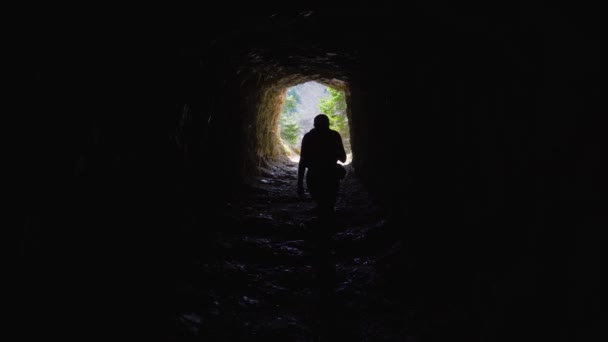 Chica camina dentro de una cueva en las montañas — Vídeo de stock