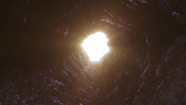 Lyset lyser opp den mørke grotten i fjellet. – stockvideo