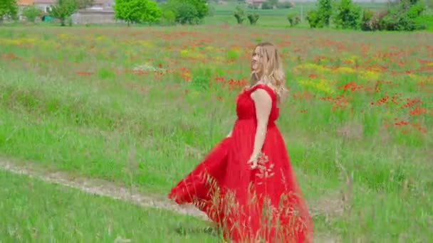 Donna con abito rosso si muove tra la natura verde — Video Stock