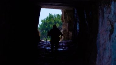 Kız dağlarda bir mağarada yürüyor.