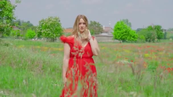 Giovane ragazza con abito rosso passeggiate tra la natura — Video Stock