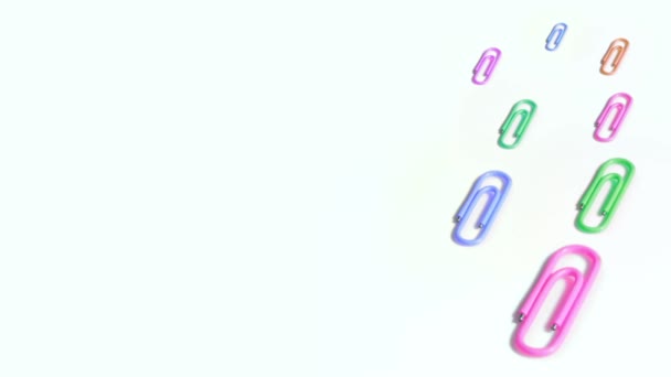 Colorful paper clips spin on white background — Stock Video