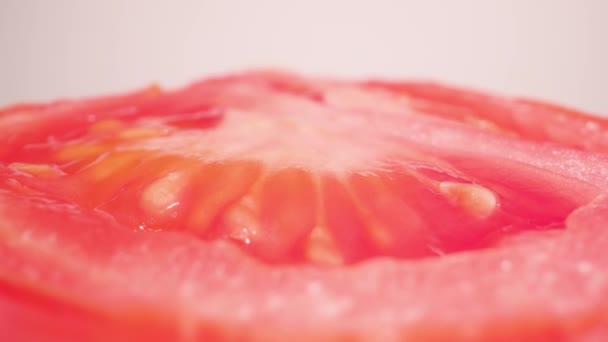 Red cut tomato rotates on white background — Αρχείο Βίντεο