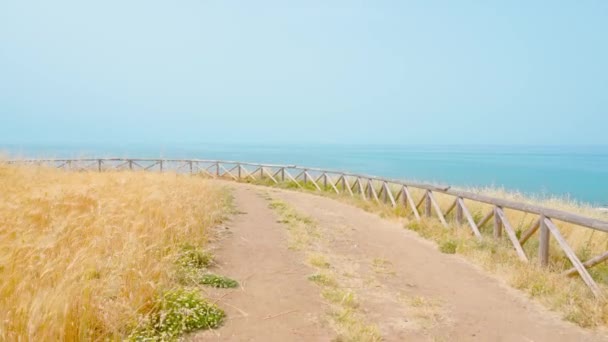 Dirt road in front of the blue sea — 图库视频影像