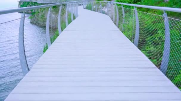 Hölzerner Radweg an Felsen über dem Fluss aufgehängt — Stockvideo