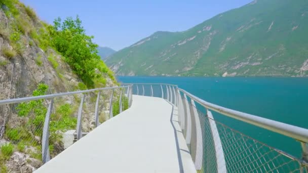 Дорога подвешена на горных скалах к озеру в Альпах — стоковое видео