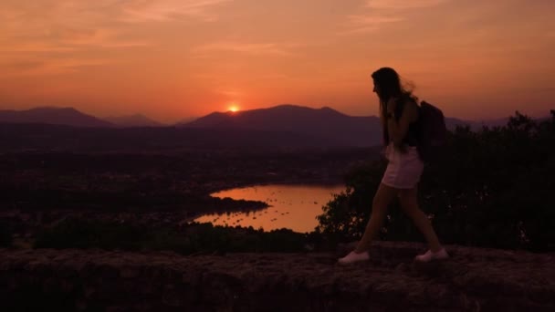 Dziewczyna spaceruje po pięknym zachodzie słońca w górach — Wideo stockowe