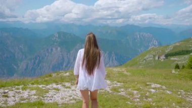 Genç kız yazın Alp dağlarında yürür.