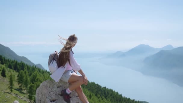 Jeune fille assise sur les montagnes en face du lac de Garde — Video