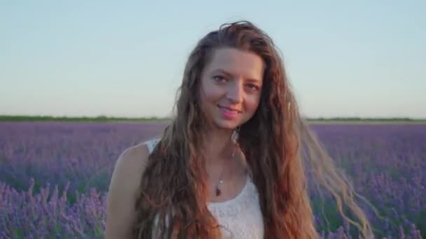 Meisje lacht voor lavendel bij zonsondergang — Stockvideo