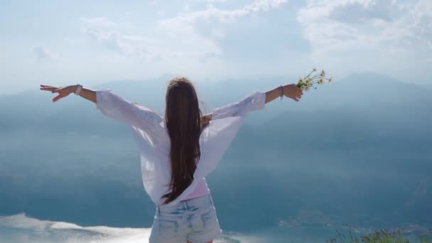 Mountains and a lake with a girl dressed in white blowing in the wind — Stock Video