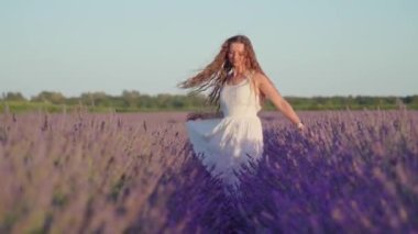 Genç kız gündüz vakti lavantanın arasında dolaşıyor.