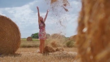 Kız yavaş çekimde havaya kuru saman fırlatıyor.
