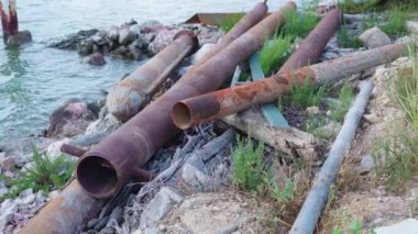 Nehrin kıyısında yerde metal borular var.