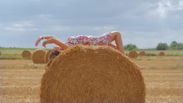 Дівчина лежить з нею спиною на стосі сіна — стокове відео