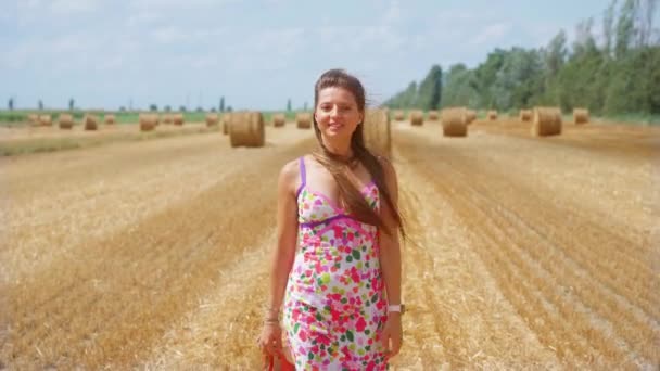 Chica camina en el campo cultivado con pajar — Vídeos de Stock