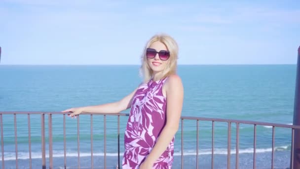 Mujer joven frente al mar en una torre — Vídeo de stock