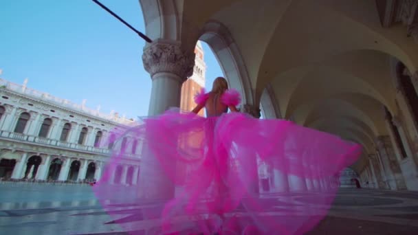 Flicka med vacker rosa klänning promenader i San Marco torget — Stockvideo