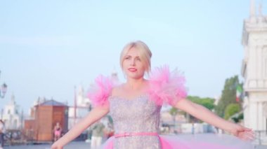 Pembe elbiseli kız Venedik 'te gülümsüyor.