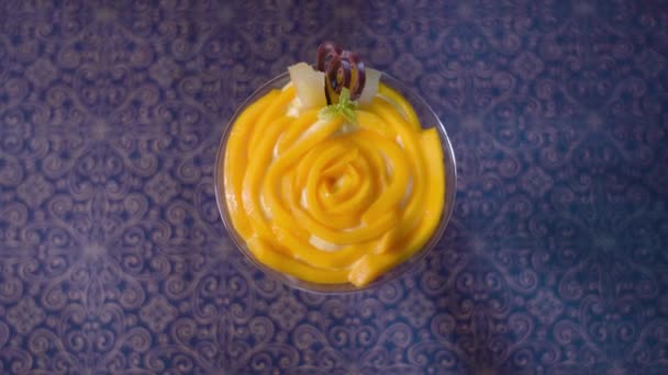 グラスの中のカスタードの上にマンゴー — ストック動画