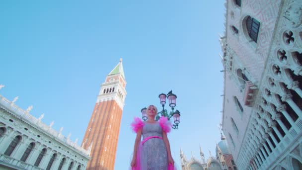 Blond flicka i rosa klänning i Venedig framför San Marco klocktornet — Stockvideo