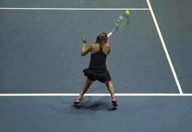 Tenis oynayan genç bir kadın.