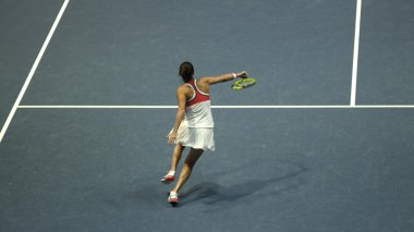 Tenis oynayan genç bir kadın.