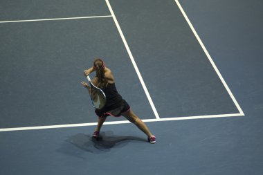 Tenis oynayan genç bir kadın.