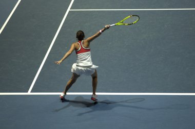 Tenis oynayan genç bir kadın.