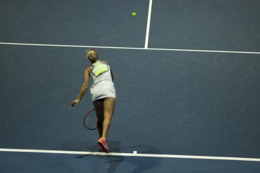 Tenis oynayan genç bir kadın.