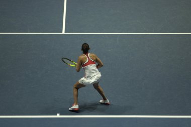 Tenis oynayan genç bir kadın.
