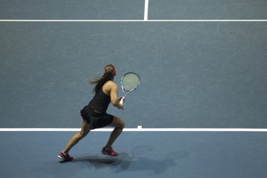 Tenis oynayan genç bir kadın.