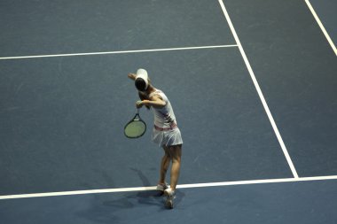 Tenis oynayan genç bir kadın.