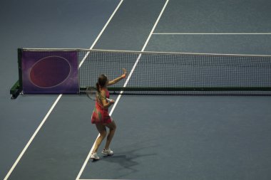 Tenis oynayan genç bir kadın.