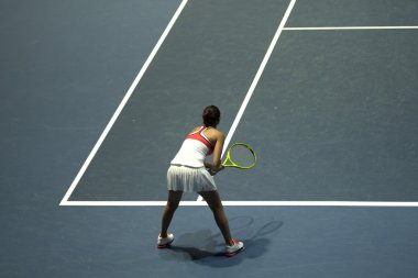 Tenis oynayan genç bir kadın.