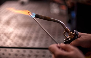 Gaz ocağı pirinçten yapılmış ve içinden alev fışkırıyor..