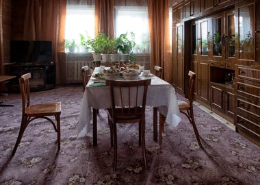 Döşemesi halı kaplı eski bir oturma odası.