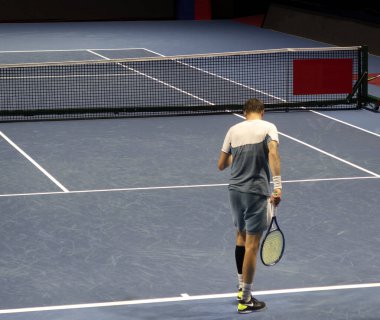 Maç sırasında tenis oyuncusu, düşme atışı için uzanıyor.