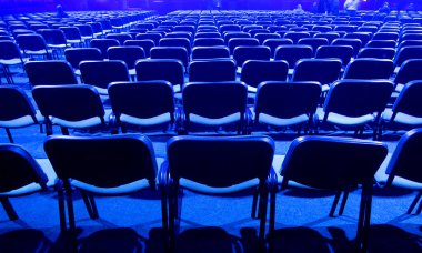 Boş bir konferans odasında mavi koltuklar..