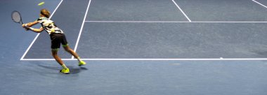 Maç sırasında tenis oyuncusu, düşme atışı için uzanıyor.