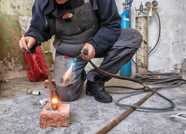 Metal meşale kullanarak çelik boru kesen işçiler