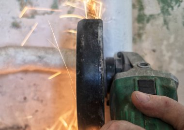 Metal meşale kullanarak çelik boru kesen işçiler