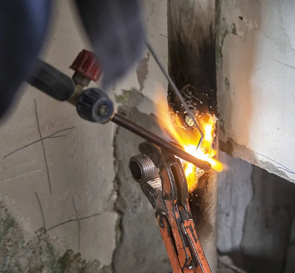 worker cutting steel pipe using metal torch