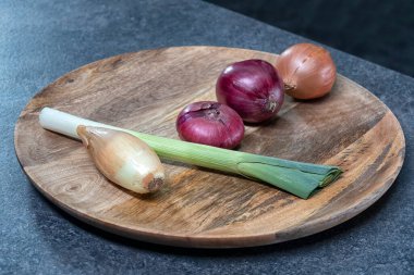 Mutfak masasında olgun sebzeler. Taze sebzeler, domatesler, patatesler, havuçlar, otlar, soğanlar pişirmeye hazır..