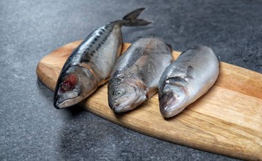 Çiğ balık. Balık pişirmeye hazır. Tahta masadaki balık ve baharatlar..