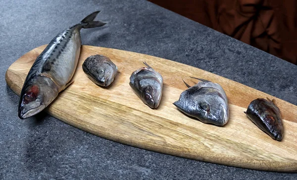 Raw fish. Fish prepared for cooking. Fish and spices on a wooden table.