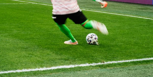 サッカー選手の足がジャンプし 自然の芝生の上でボールを制御している — ストック写真